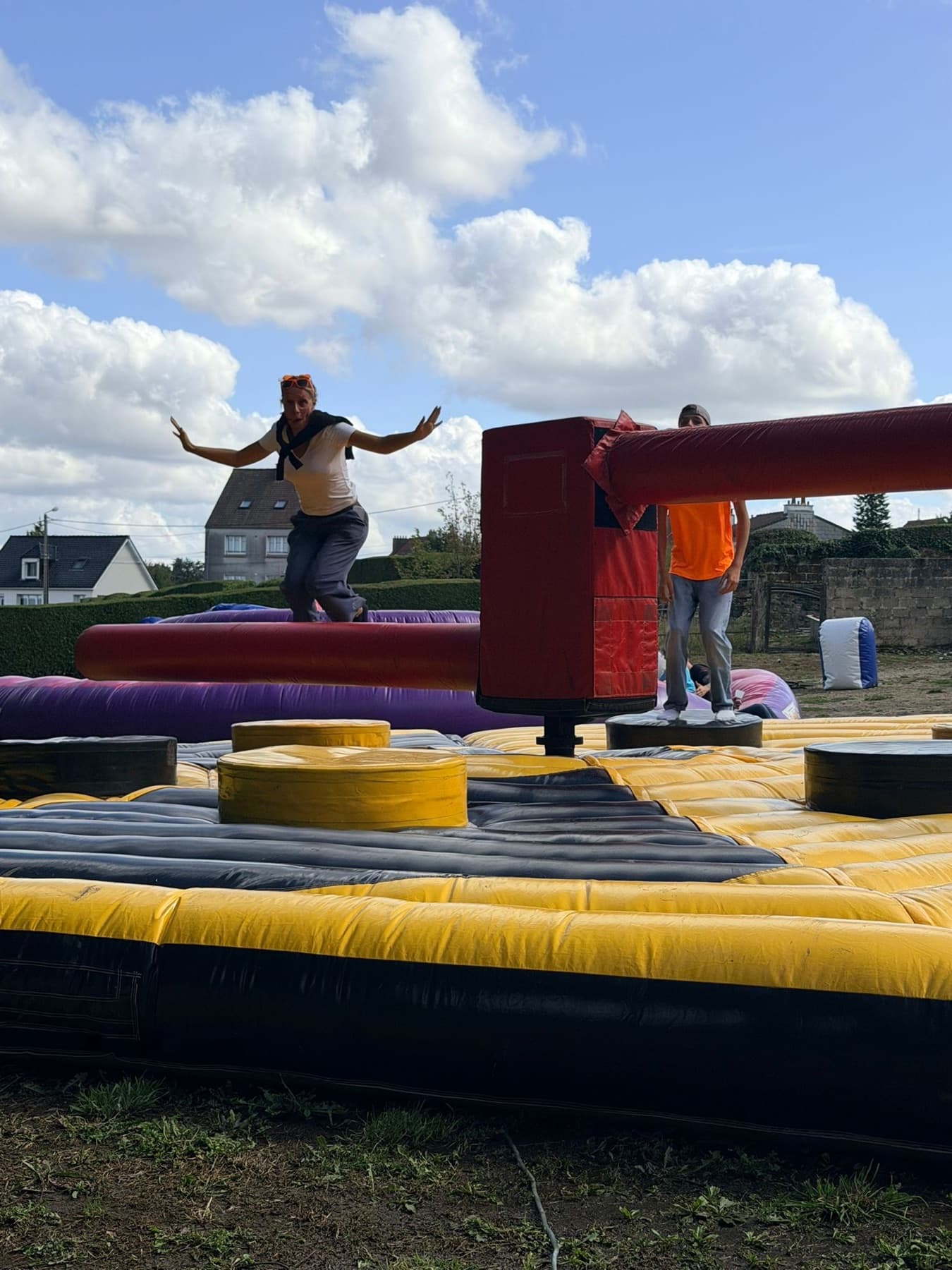 Participant sur un parcours d'obstacles gonflable en plein air.