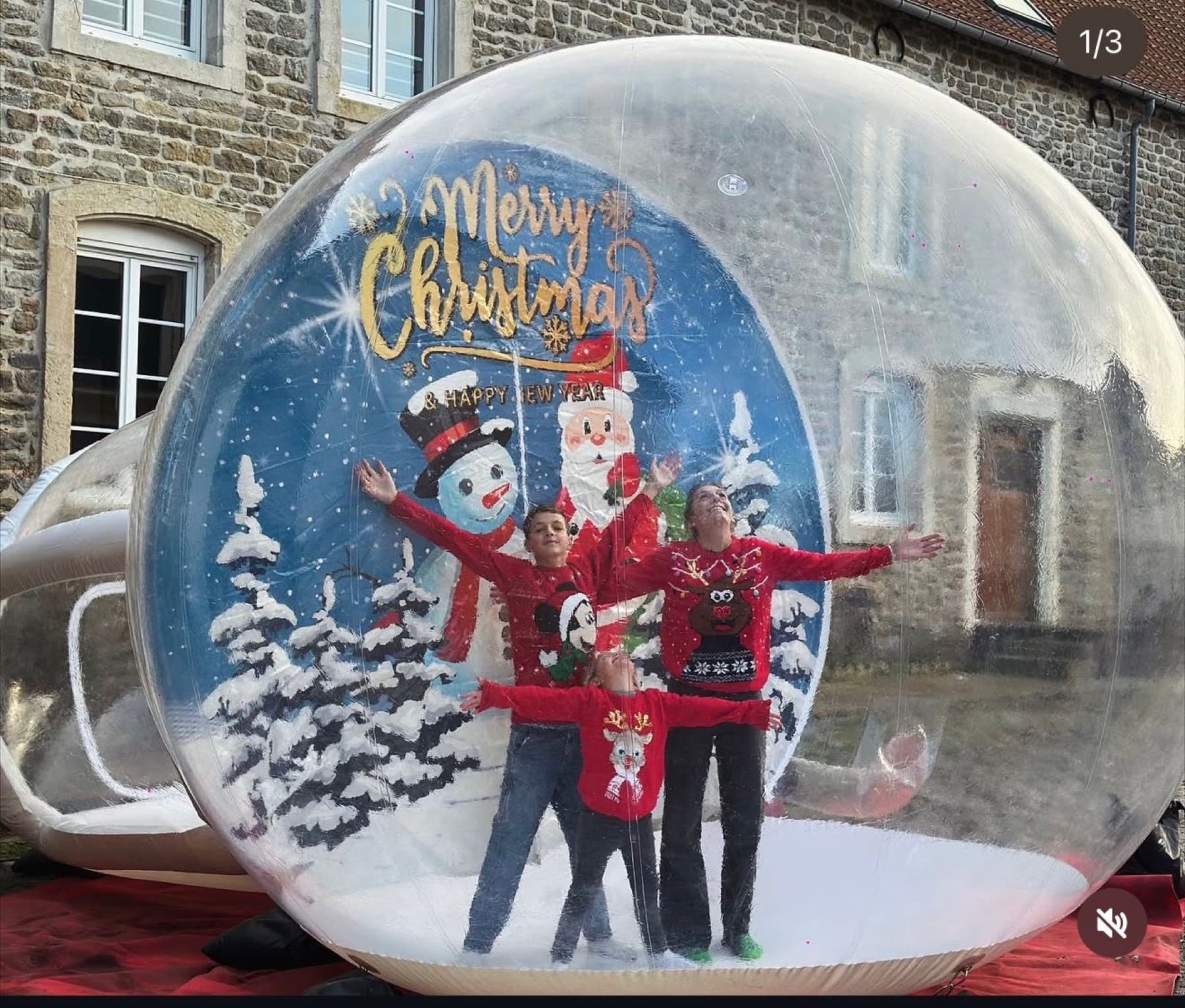 Boule à neige géante gonflable avec une famille à l'intérieur.